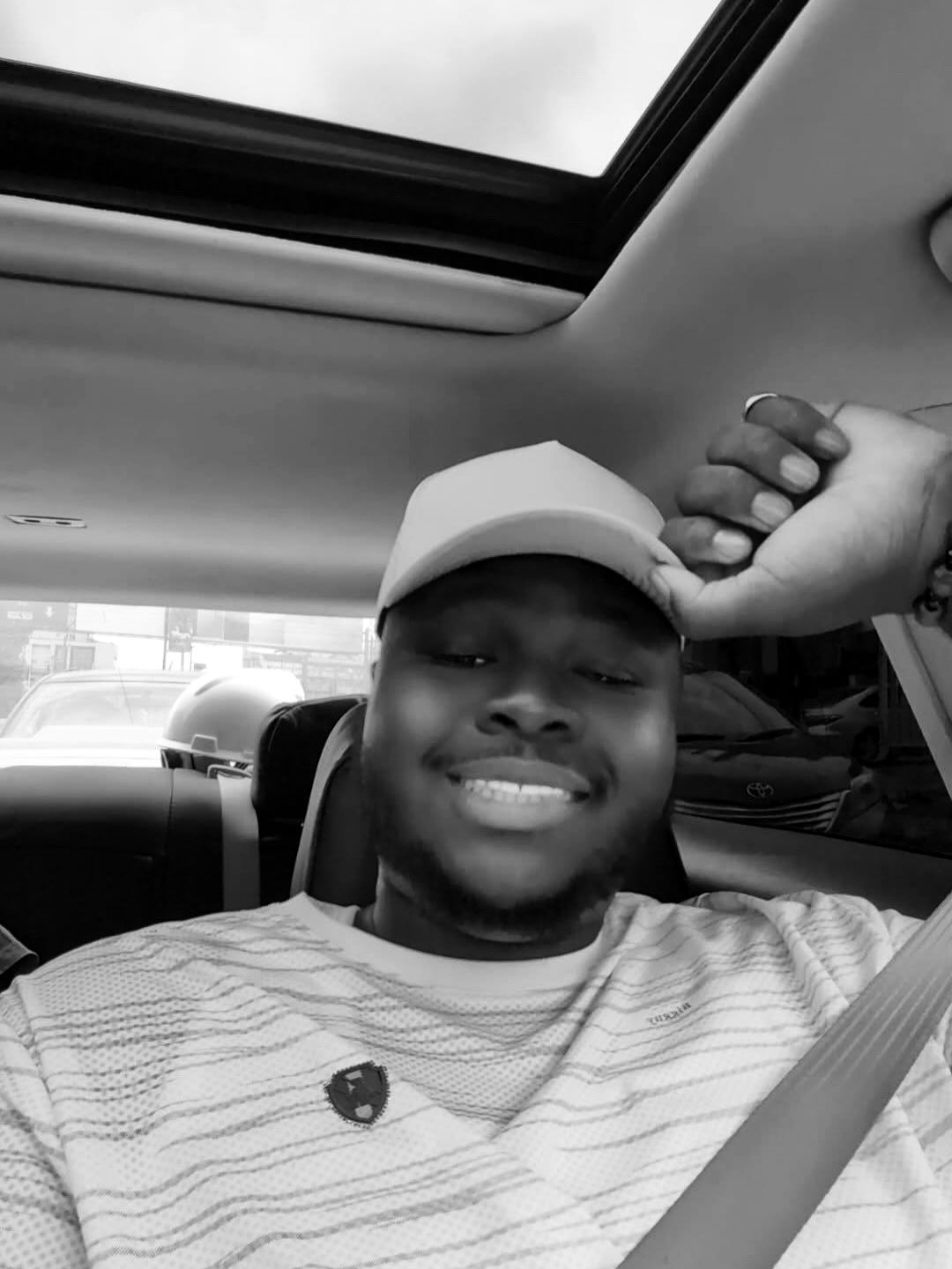 Harold smiling in the driver's seat, cap on