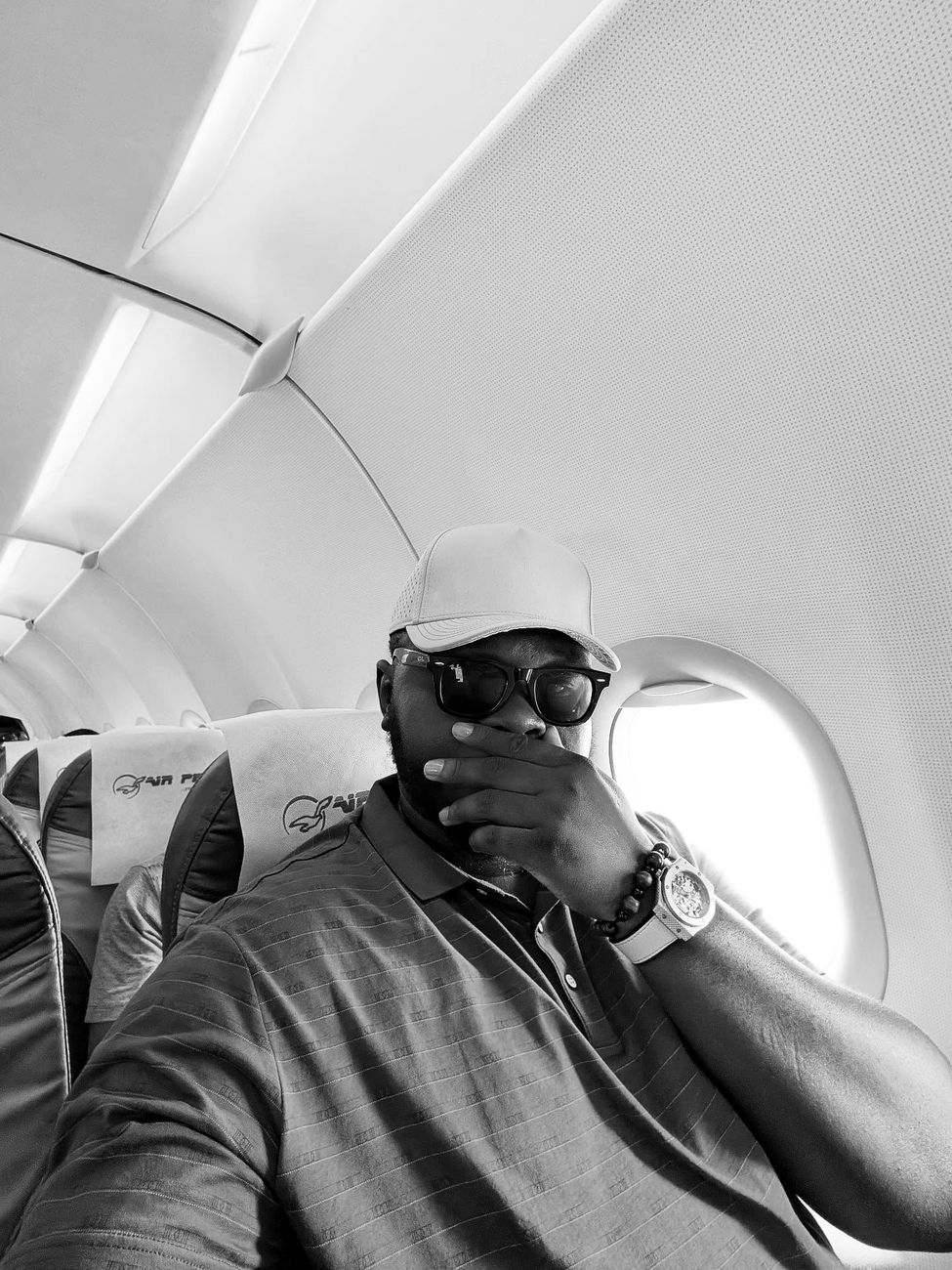 Harold in a plane seat with sunglasses on