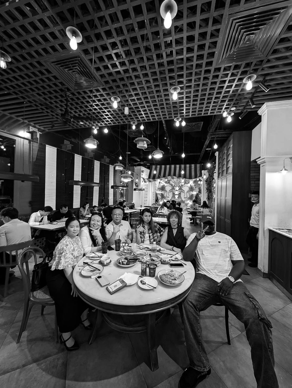 Harold at a round dinner table with his team in Singapore