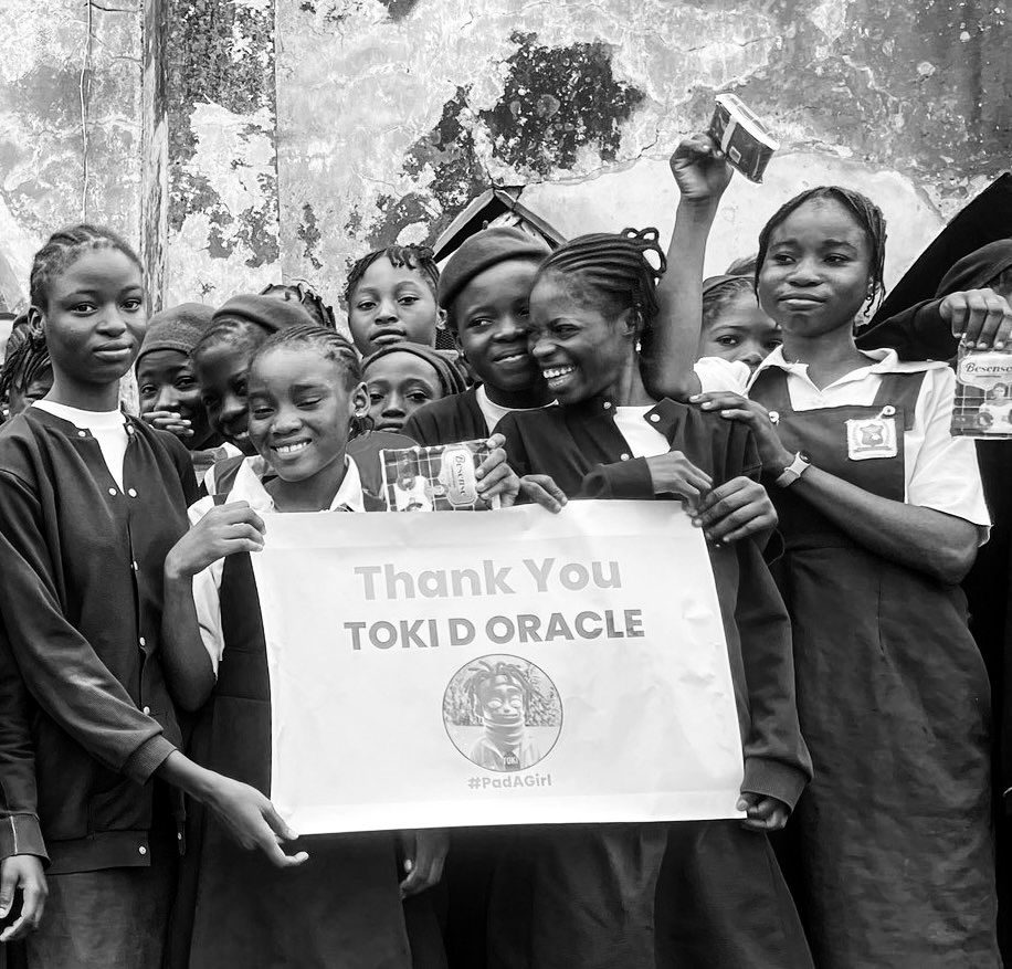 Schoolgirls in uniform holding a banner that reads Thank You Toki D Oracle, #PadAGirl