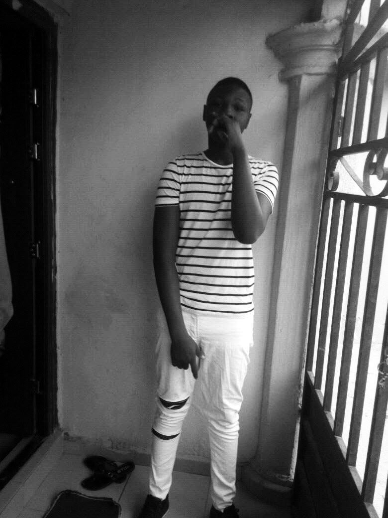 A younger Harold in a striped shirt, standing by a window with burglar bars